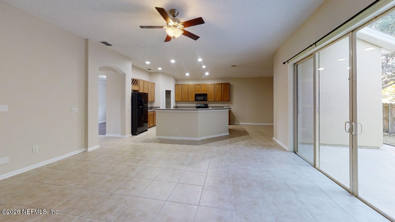 14454 Millhopper Road Jacksonville, FL 32258 - Photo 18 of 44 a view of a kitchen with a refrigerator and a ceiling fan