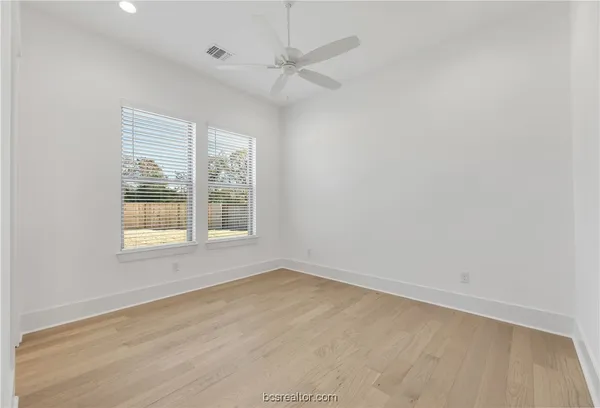 a view of a hall with wooden floor and a large window