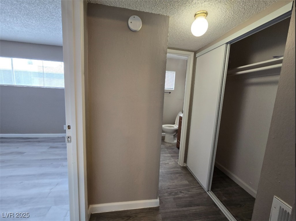 Undisclosed Address Las Vegas, NV 89101 - Photo 6 of 11 Corridor with a textured ceiling, wood finished fl