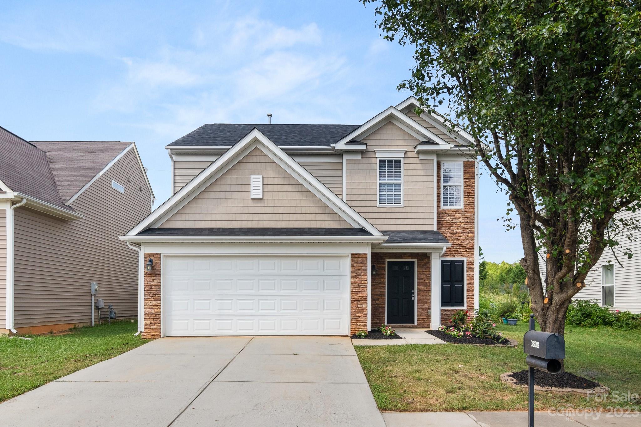 a front view of a house with yard and green space