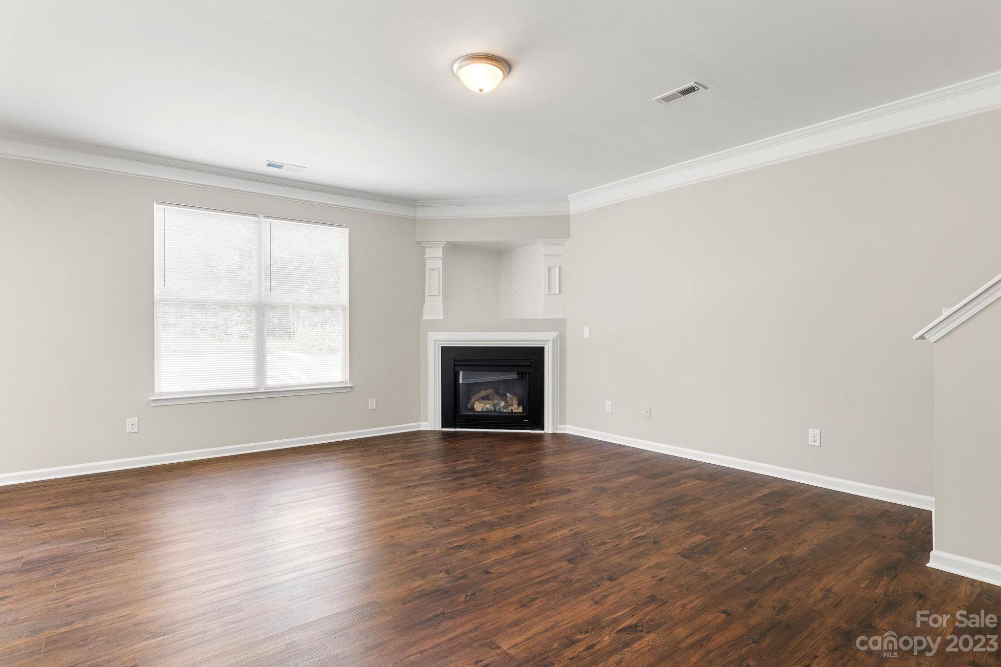 3808 Herkimer Drive Monroe, NC 28110 - Photo 7 of 40 an empty room with wooden floor and fireplace
