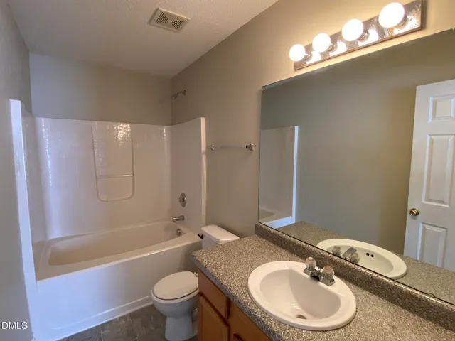 a bathroom with a double vanity sink toilet mirror and bathtub