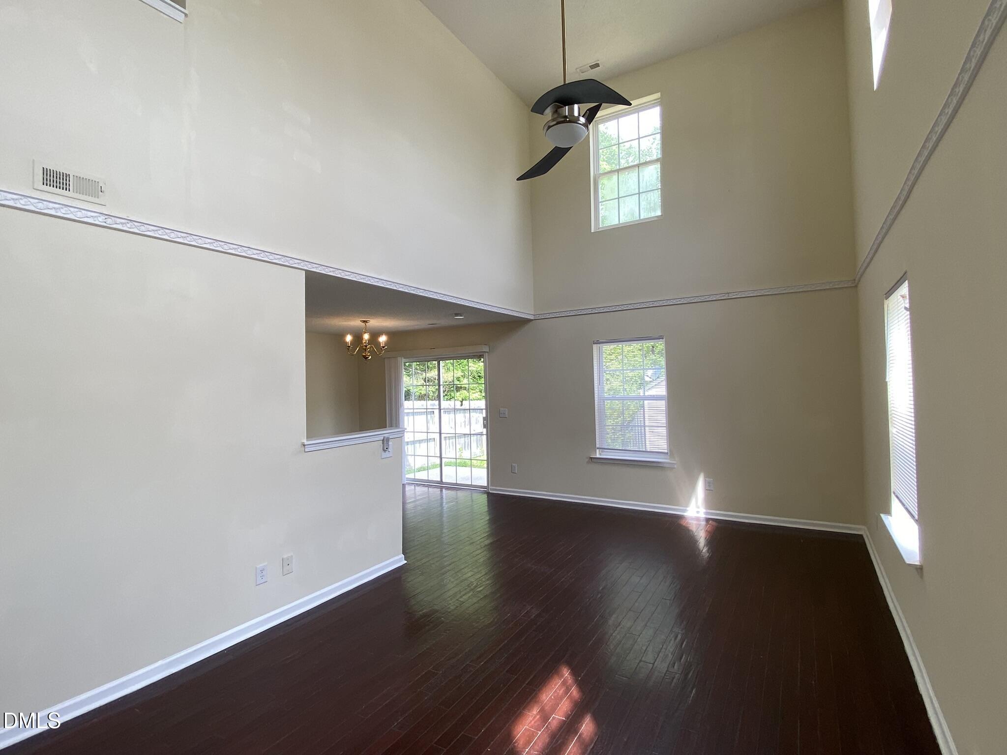5815 Ricker Road Raleigh, NC 27610 - Photo 2 of 19 an empty room with wooden floor and windows