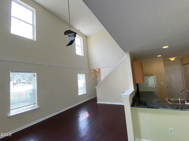 a view of a hallway with wooden floor and windows