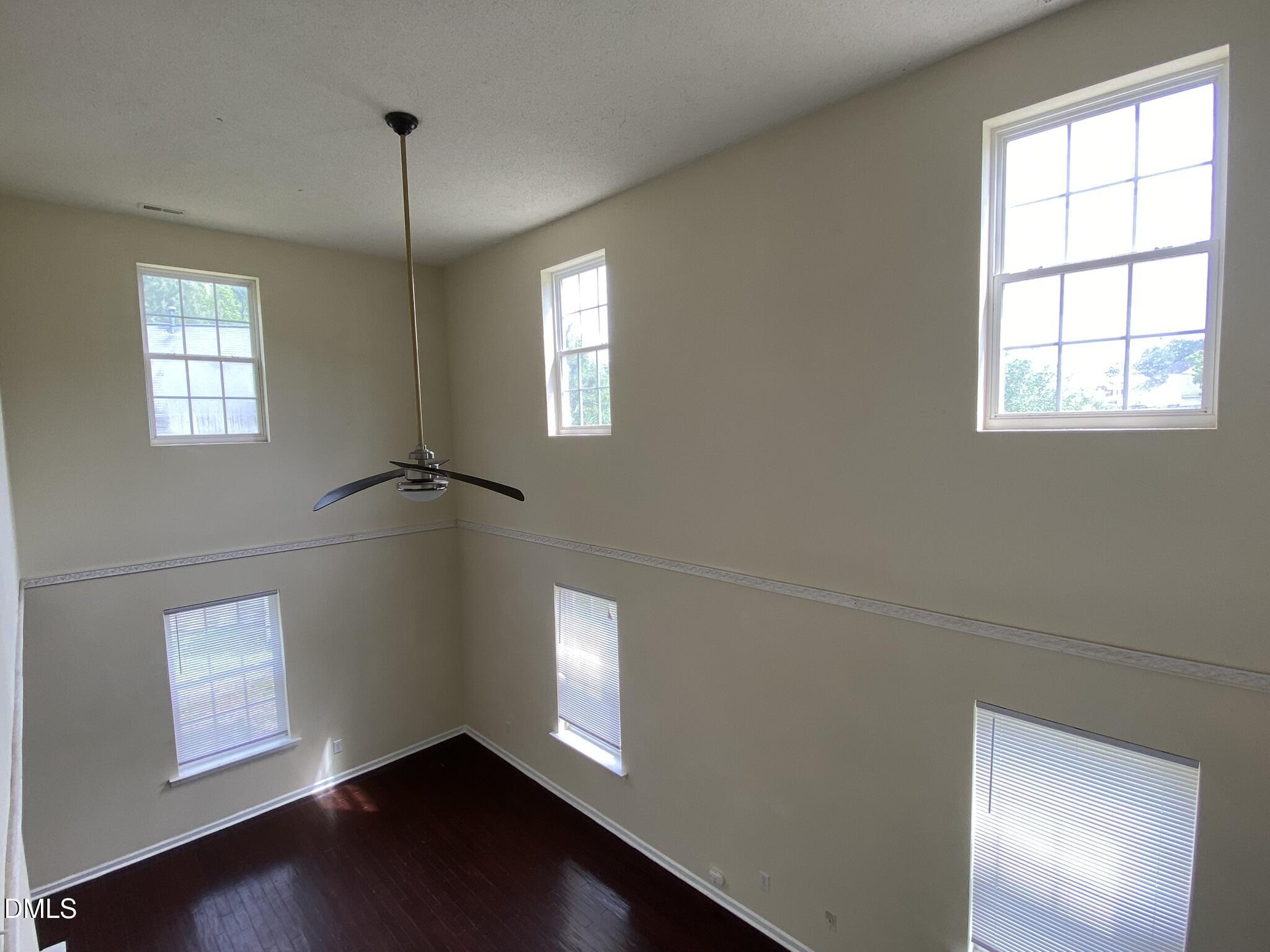 5815 Ricker Road Raleigh, NC 27610 - Photo 4 of 19 a view of an empty room with a window and wooden floor