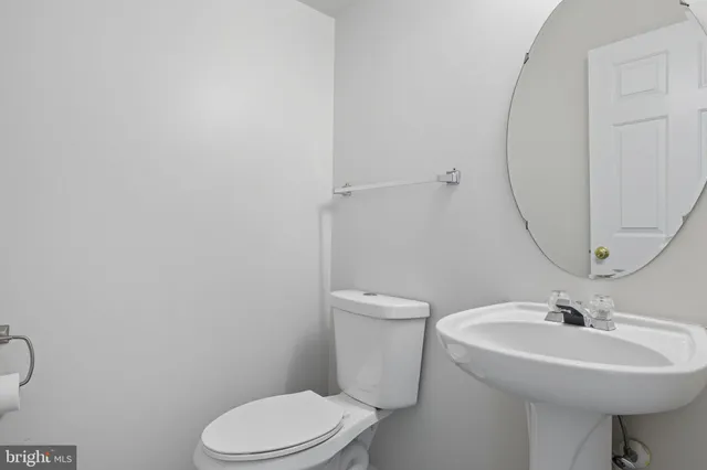 an empty room with wooden floor mirror and windows