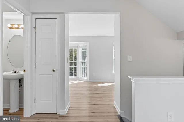 a view of an empty room with wooden floor and windows