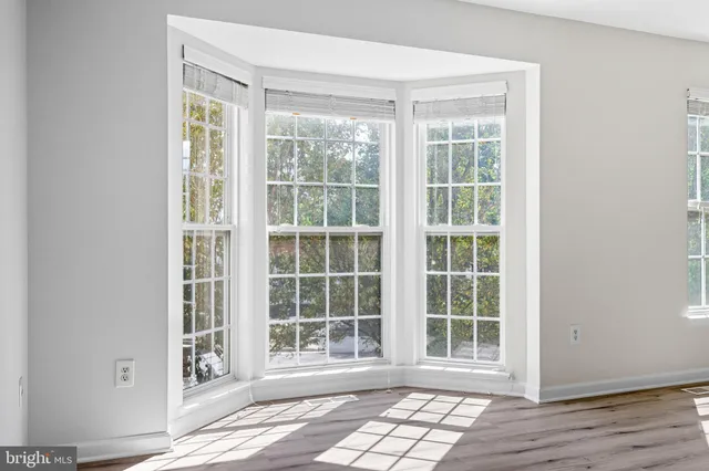 a view of empty room with wooden floor and window