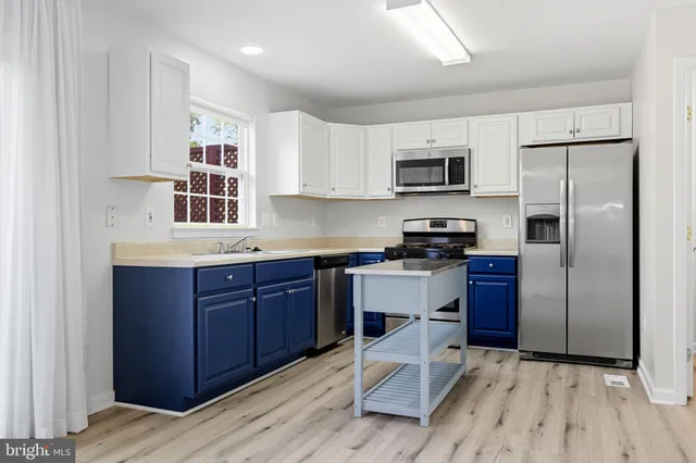 a kitchen with granite countertop a refrigerator and a stove top oven