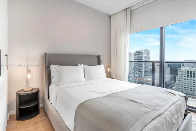 a bedroom with a balcony a bed and a chair