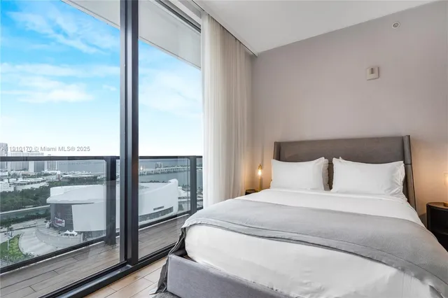 a bedroom with a large window and a balcony