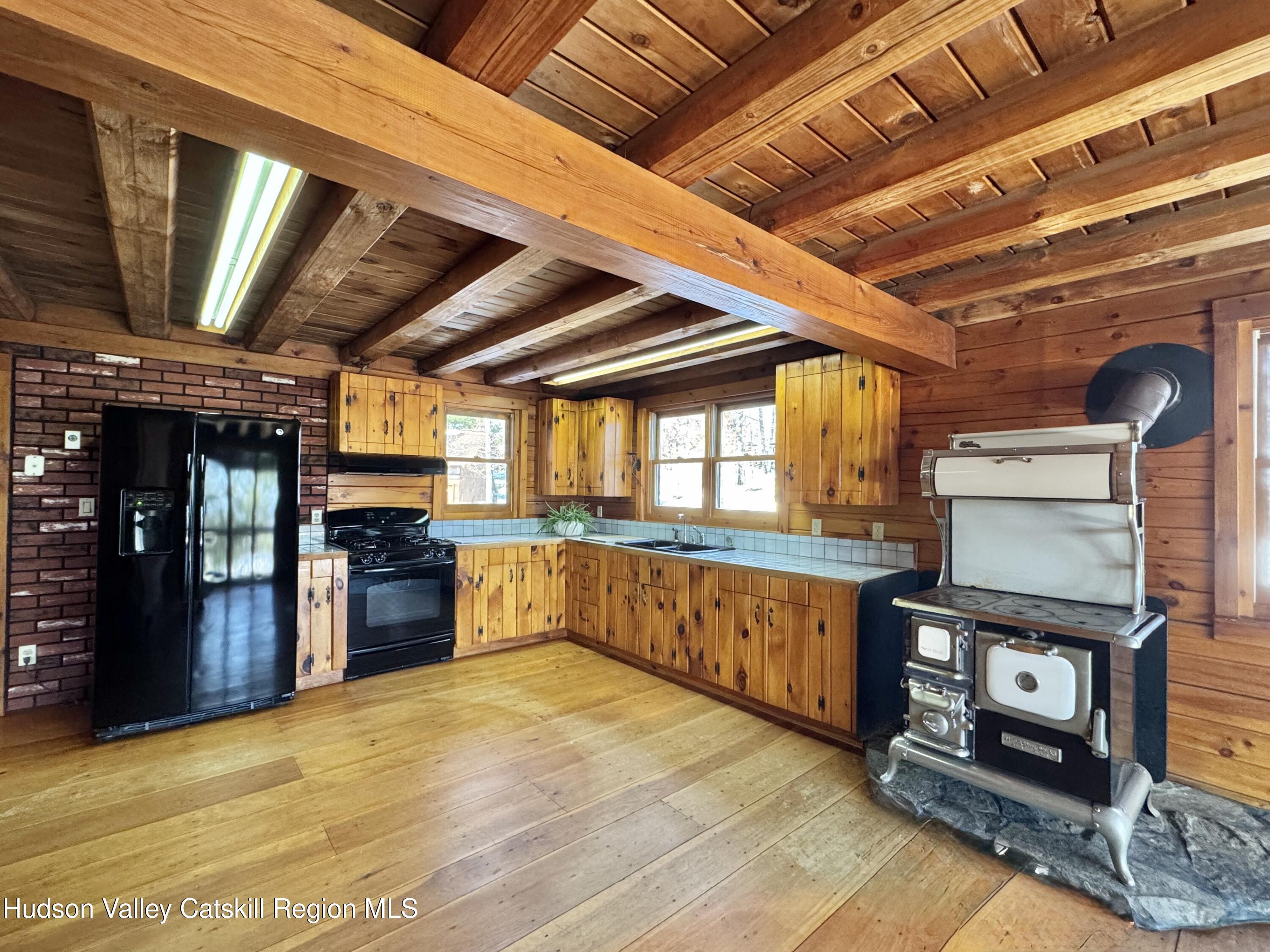 380 Easy Street Catskill, NY 12414 - Photo 22 of 57 a large kitchen with stainless steel appliances wooden cabinets a sink and a stove