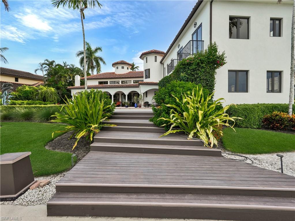 2535 Tarpon Road Naples, FL 34102 - Photo 46 of 50 Mediterranean-style residence featuring a terracotta tile roof, multiple balconies with dark railings, and a prominent tower