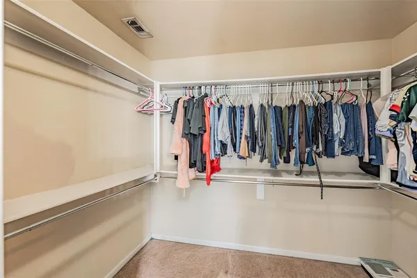 a view of walk in closet with clothes