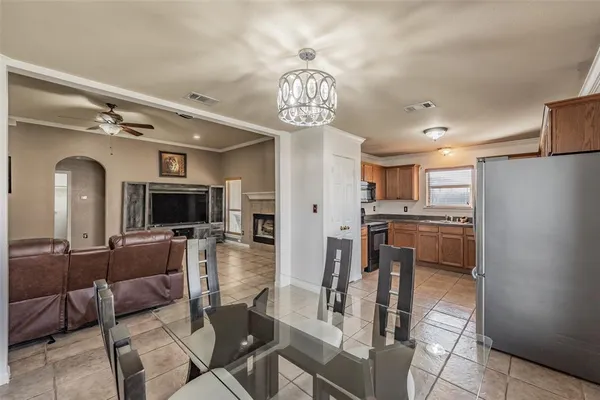 a living room with furniture a flat screen tv and kitchen view