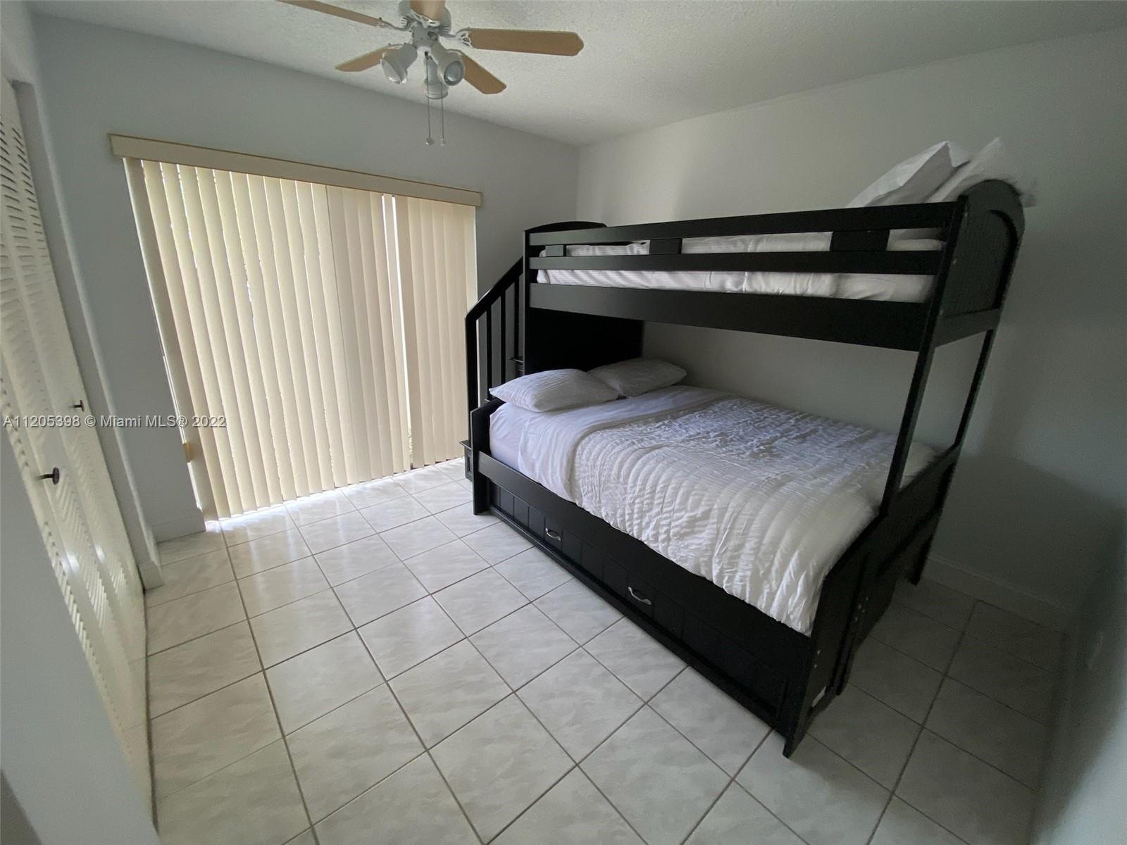 10478 Southwest 75th Lane Miami, FL 33173 - Photo 17 of 45 a bedroom with a bed and window
