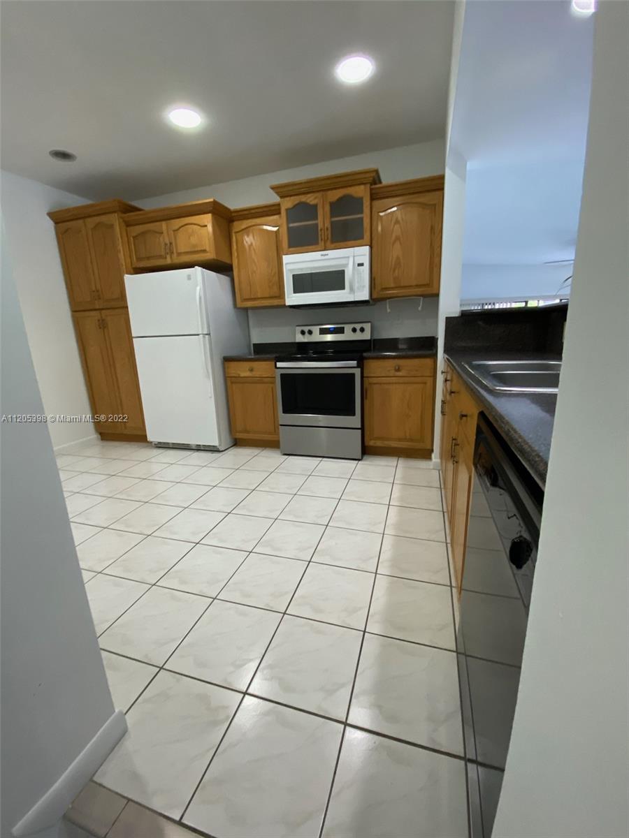 10478 Southwest 75th Lane Miami, FL 33173 - Photo 19 of 45 a kitchen with granite countertop a stove and cabinets