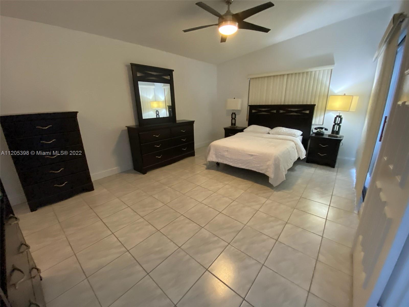 10478 Southwest 75th Lane Miami, FL 33173 - Photo 23 of 45 a bedroom with a bed and a lamp on dresser