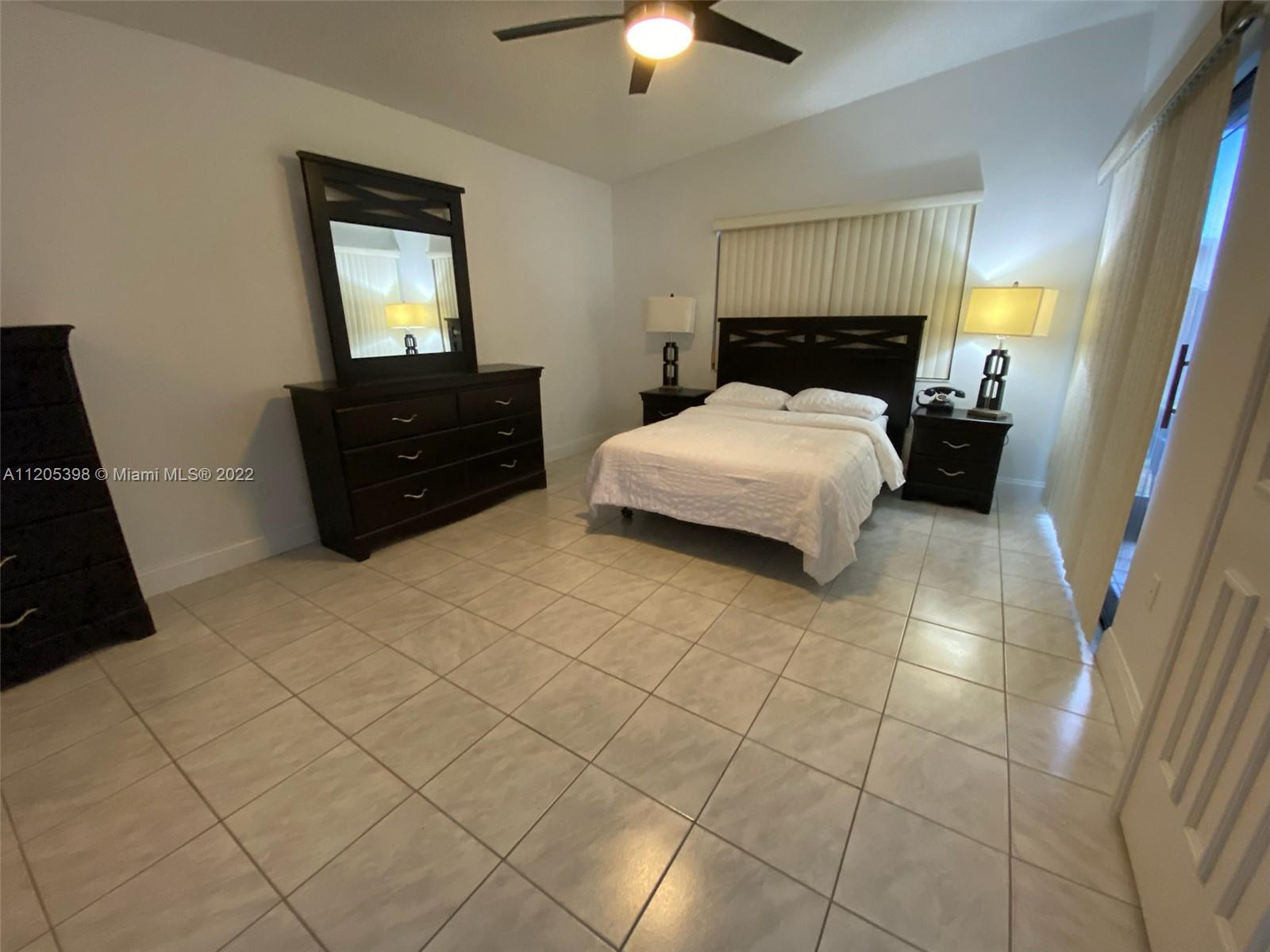 10478 Southwest 75th Lane Miami, FL 33173 - Photo 24 of 45 a bedroom with a bed and a chandelier
