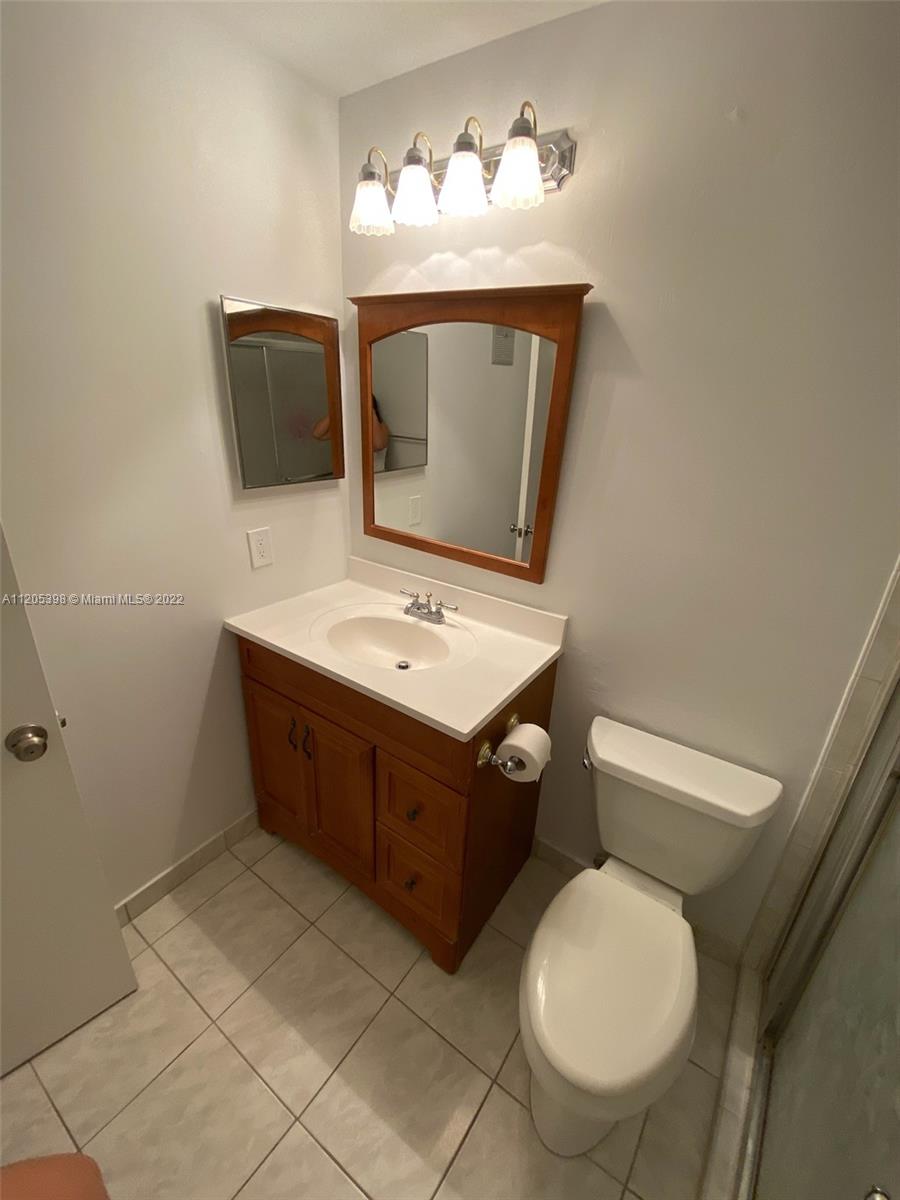 10478 Southwest 75th Lane Miami, FL 33173 - Photo 29 of 45 a bathroom with a sink mirror and toilet