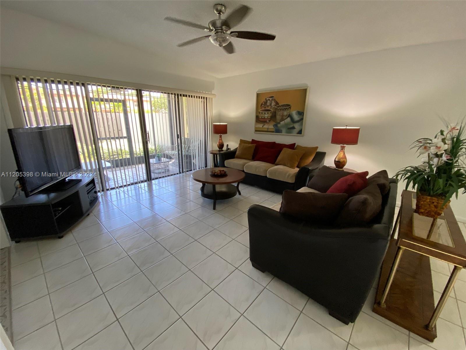 10478 Southwest 75th Lane Miami, FL 33173 - Photo 31 of 45 a living room with furniture and a flat screen tv