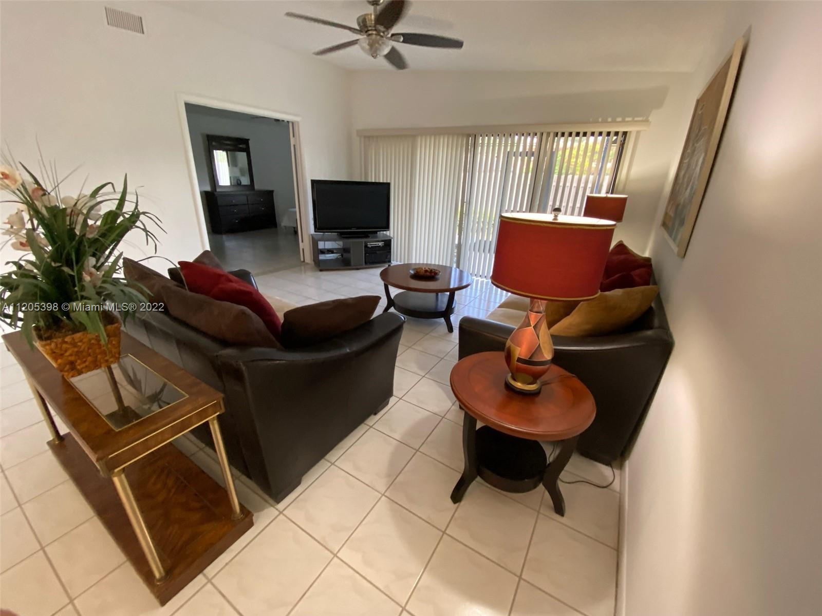 10478 Southwest 75th Lane Miami, FL 33173 - Photo 38 of 45 a living room with furniture and a flat screen tv