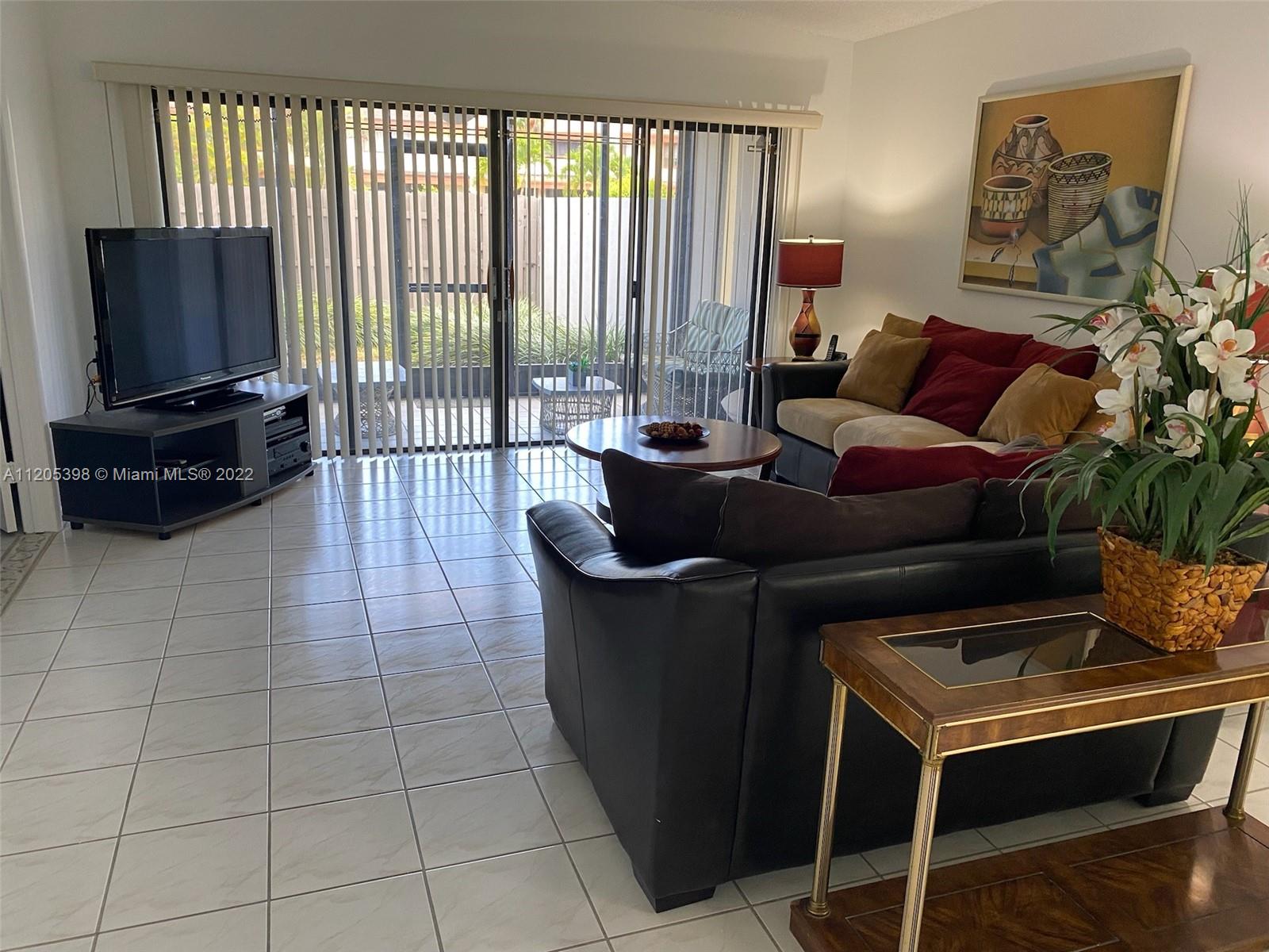 10478 Southwest 75th Lane Miami, FL 33173 - Photo 40 of 45 a living room with furniture and a flat screen tv