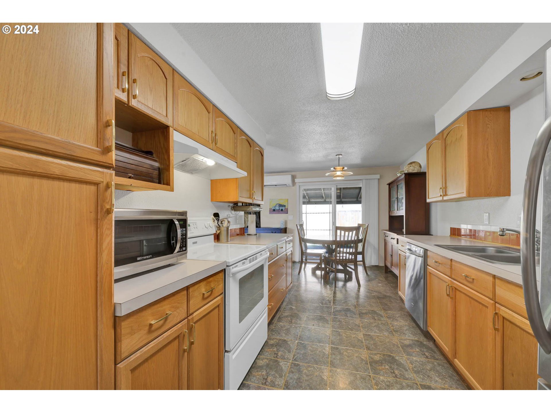 2301 Compton Street Eugene, OR 97404 - Photo 11 of 27 a kitchen with stainless steel appliances kitchen island granite countertop a stove top oven a sink dishwasher and white cabinets