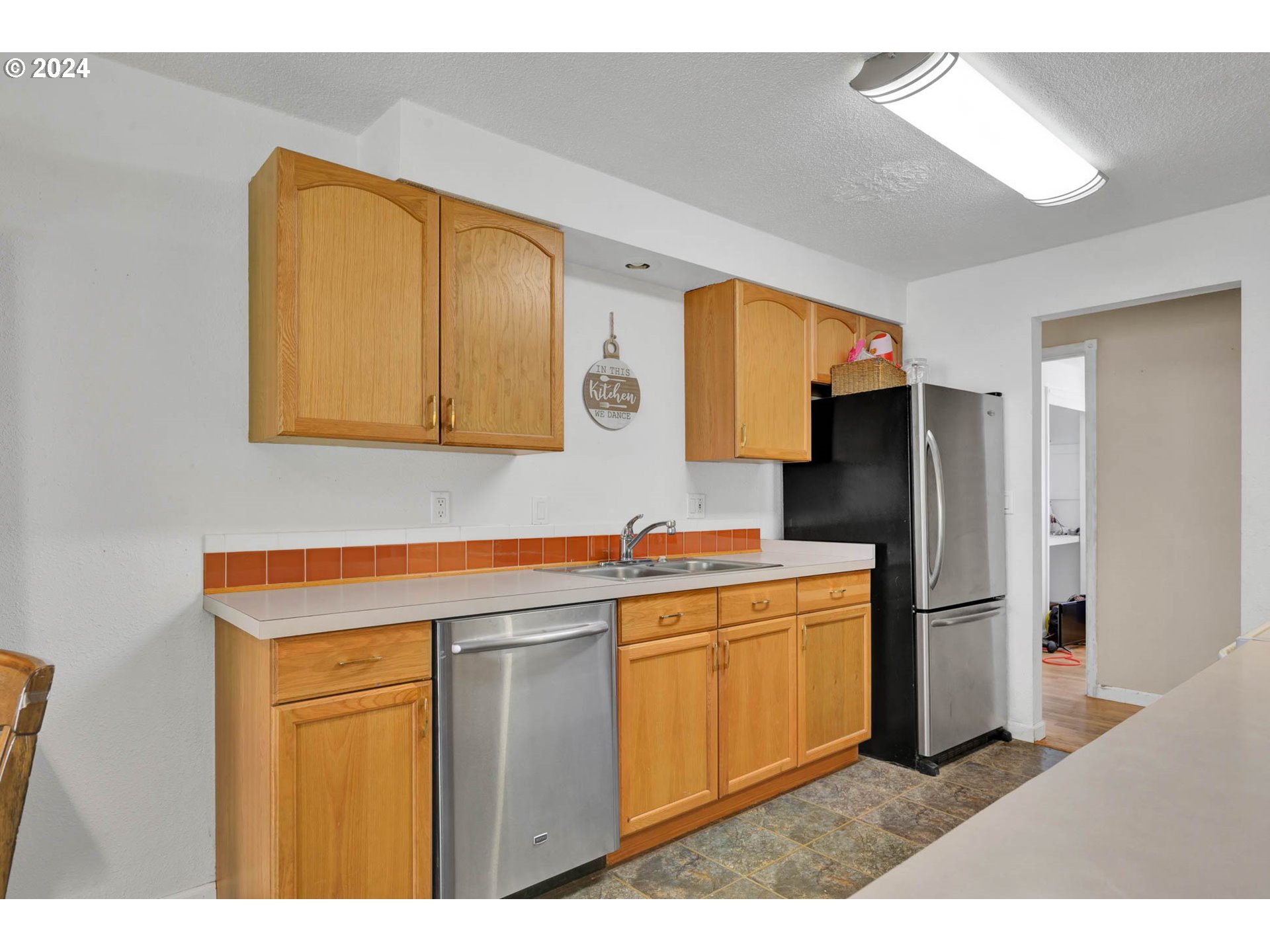2301 Compton Street Eugene, OR 97404 - Photo 9 of 27 a kitchen with stainless steel appliances granite countertop a refrigerator a stove and a sink with wooden floor