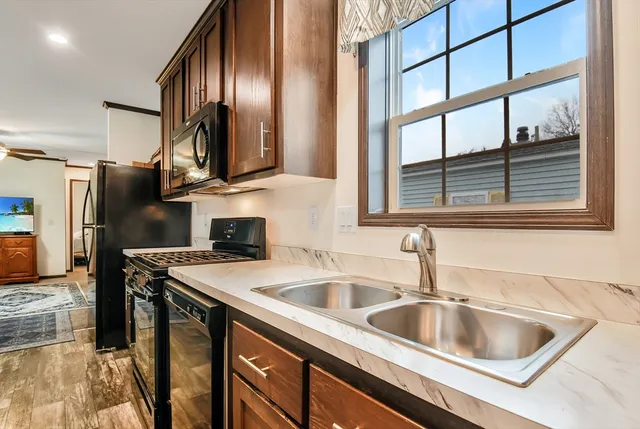 a kitchen with stainless steel appliances granite countertop a sink and a refrigerator