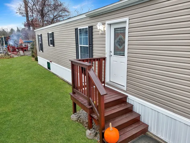 a view of a house with a yard and furniture
