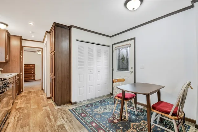 a view of a hallway with chairs and kitchen view