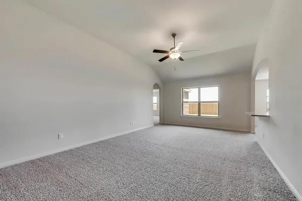 a view of a big room with windows and chandelier fan