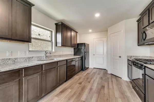 a kitchen with stainless steel appliances granite countertop a sink stove and refrigerator