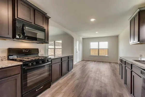 a kitchen with stainless steel appliances a stove sink microwave and cabinets