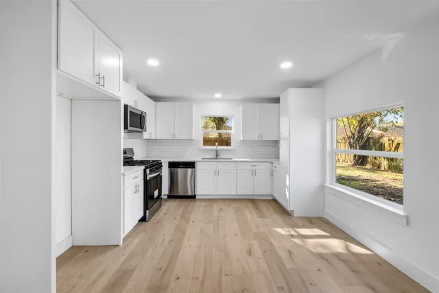 a kitchen with stainless steel appliances a refrigerator sink and cabinets