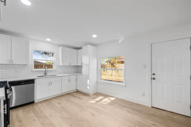 a kitchen with granite countertop cabinets stainless steel appliances a sink and a window