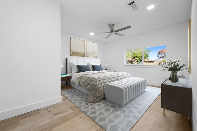a spacious bedroom with a bed and a potted plant