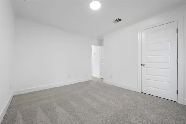 an empty room with fan and windows