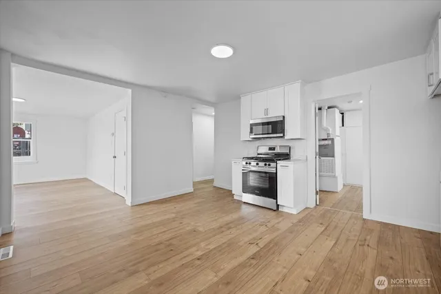 a kitchen with granite countertop a refrigerator and a stove top oven