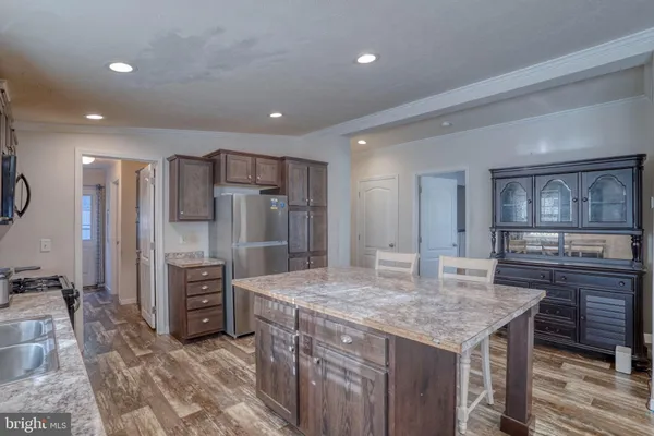 a kitchen with stainless steel appliances granite countertop a sink refrigerator and cabinets