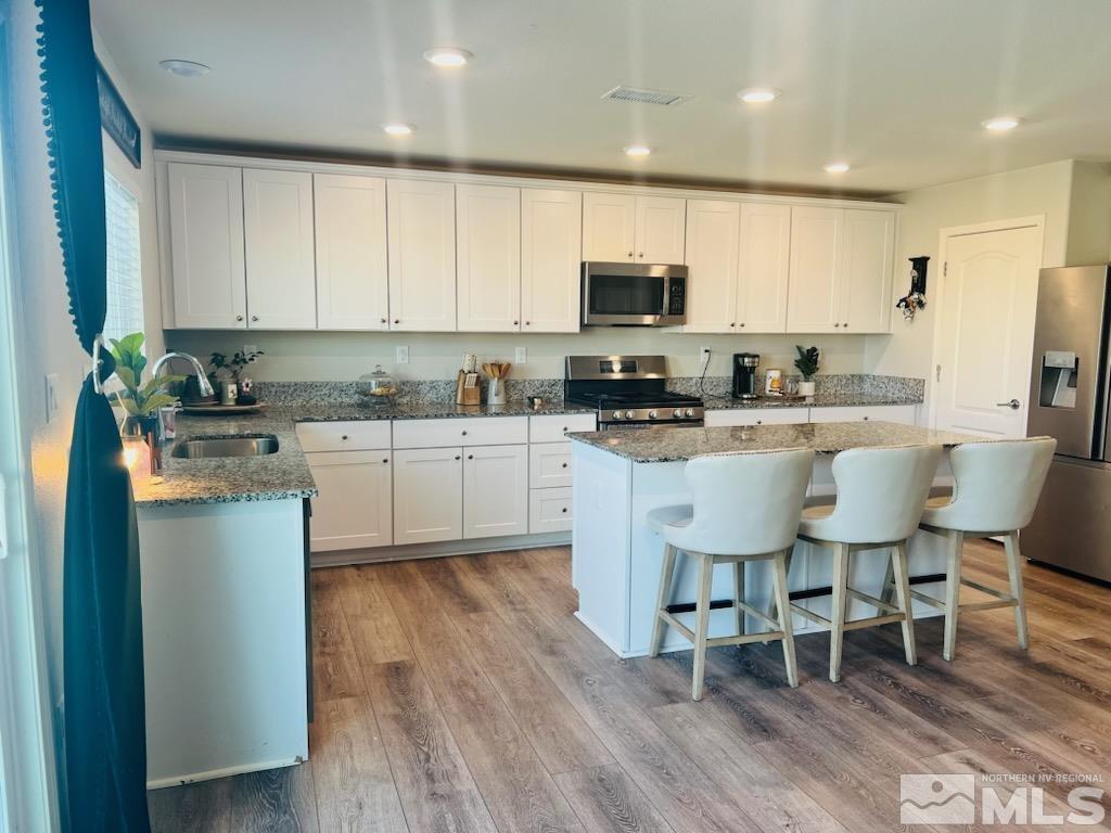8908 Quail Falls Drive Reno, NV 89506 - Photo 17 of 17 a kitchen with stainless steel appliances a microwave a sink a stove a table and chairs
