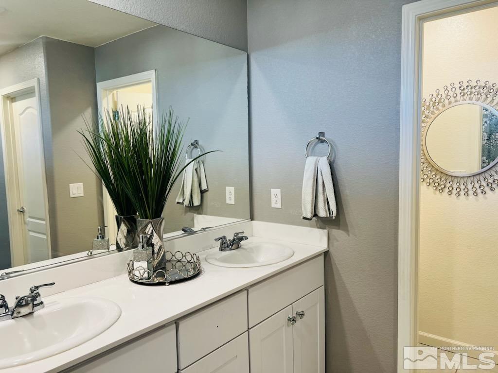 8908 Quail Falls Drive Reno, NV 89506 - Photo 9 of 17 a bathroom with a double vanity sink and a mirror