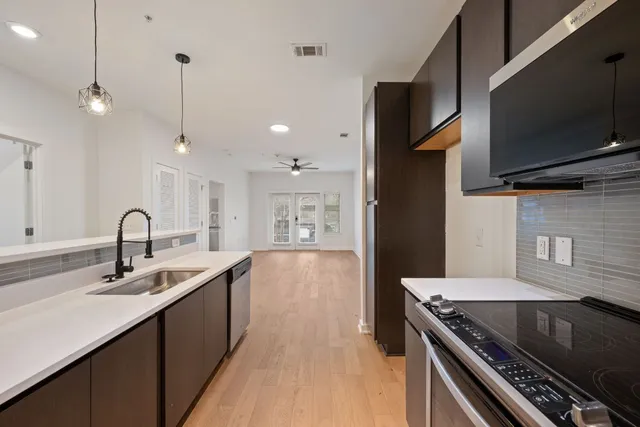 a kitchen with stainless steel appliances a sink dishwasher a refrigerator and a stove