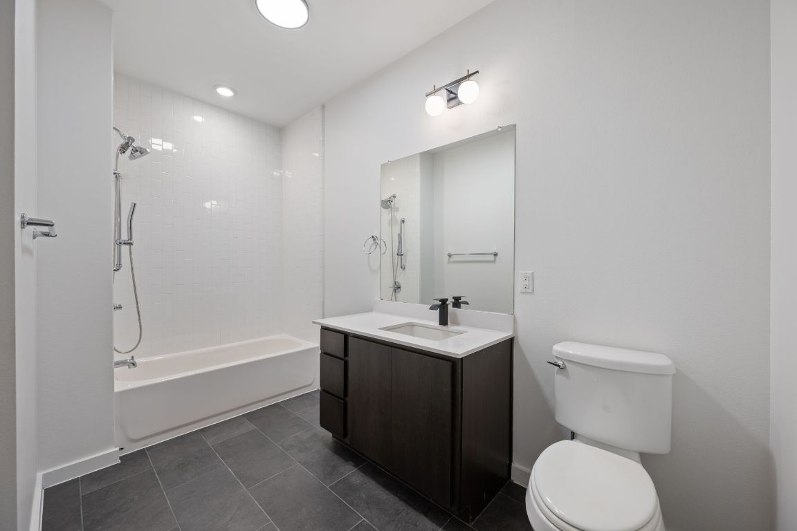 2505 Thornton Road, Unit 3103 Austin, TX 78704 - Photo 14 of 29 a bathroom with a toilet a sink a mirror and bathtub