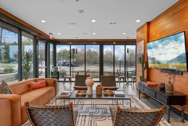 a living room with furniture a rug and a large window