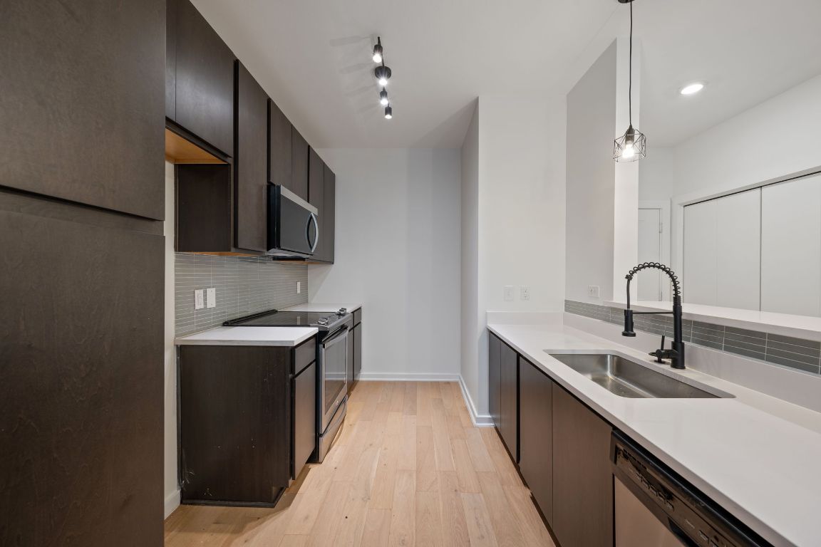 2505 Thornton Road, Unit 3103 Austin, TX 78704 - Photo 4 of 29 a kitchen with stainless steel appliances granite countertop a sink stove and refrigerator
