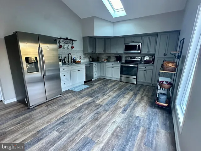 a kitchen with stainless steel appliances granite countertop a stove a microwave and a white cabinets