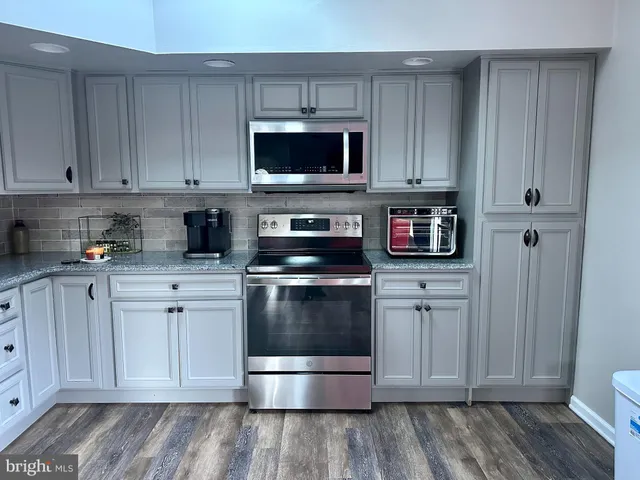 a kitchen with cabinets appliances and a counter space