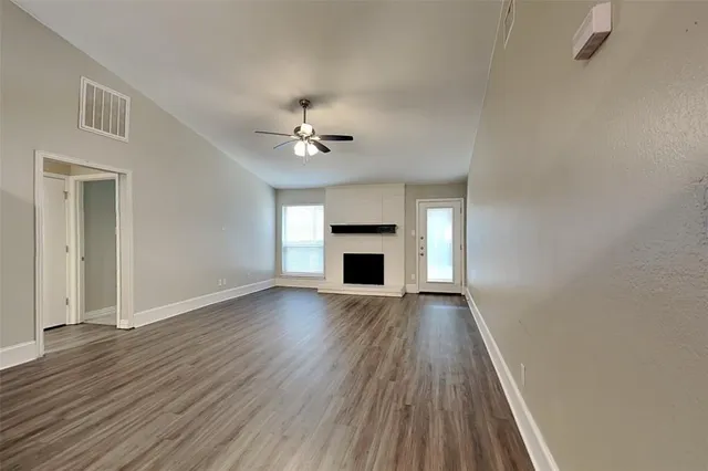 an empty room with wooden floor and fireplace